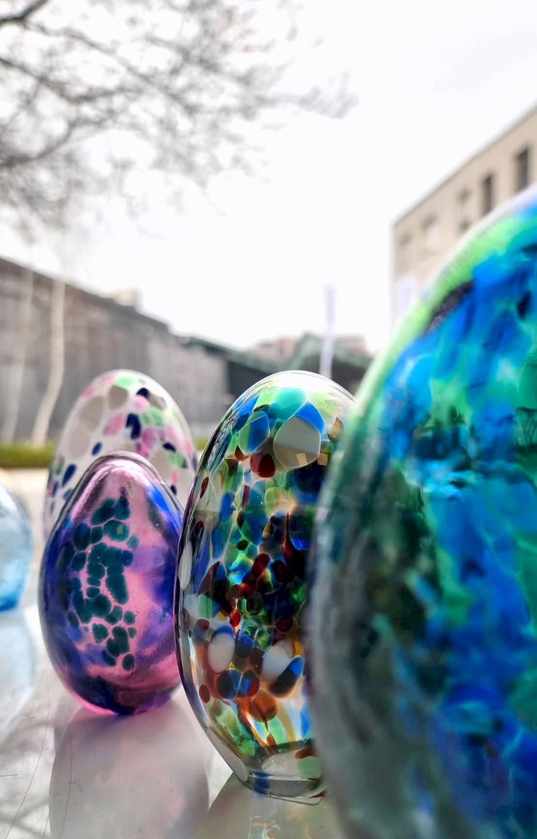 4 szklane jajka kolorowymi plamkami w barwach niebieskich, zielonych i fioletowych 